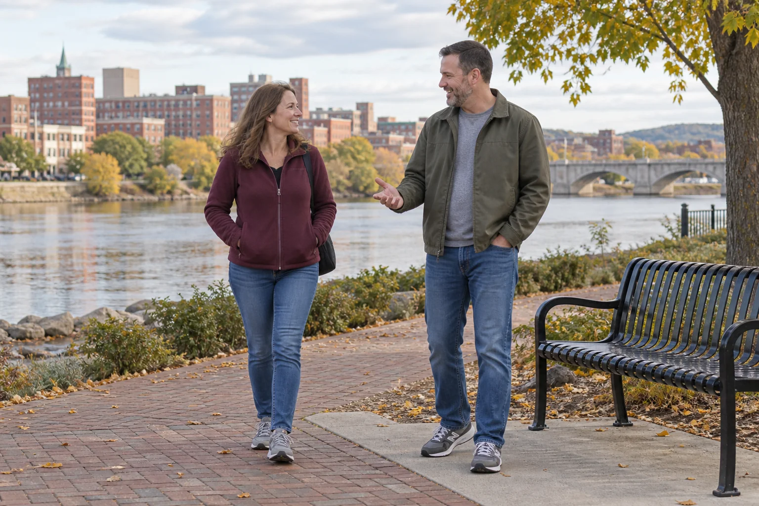 A couple on an easy riverside walk beside a public bench
