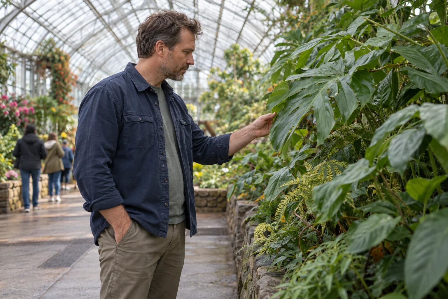 A man looking at plants during a conservatory visit